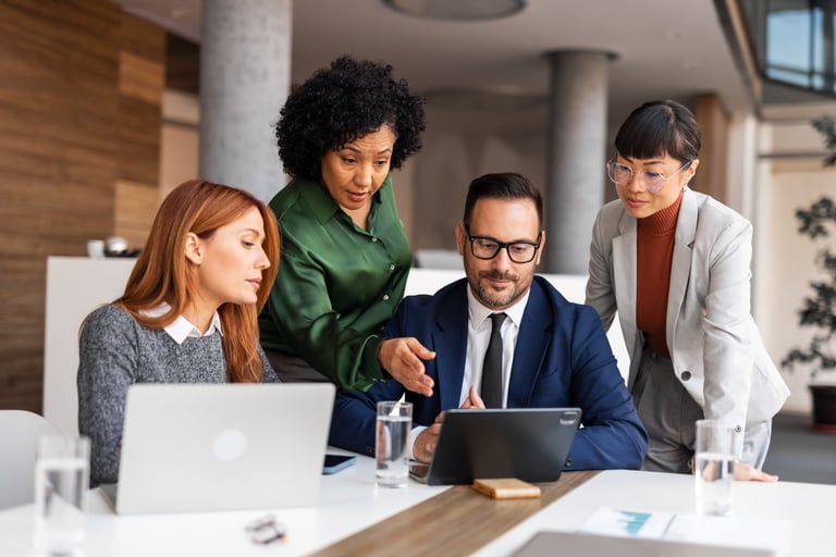 Professionals collaborate in a modern office environment with laptops